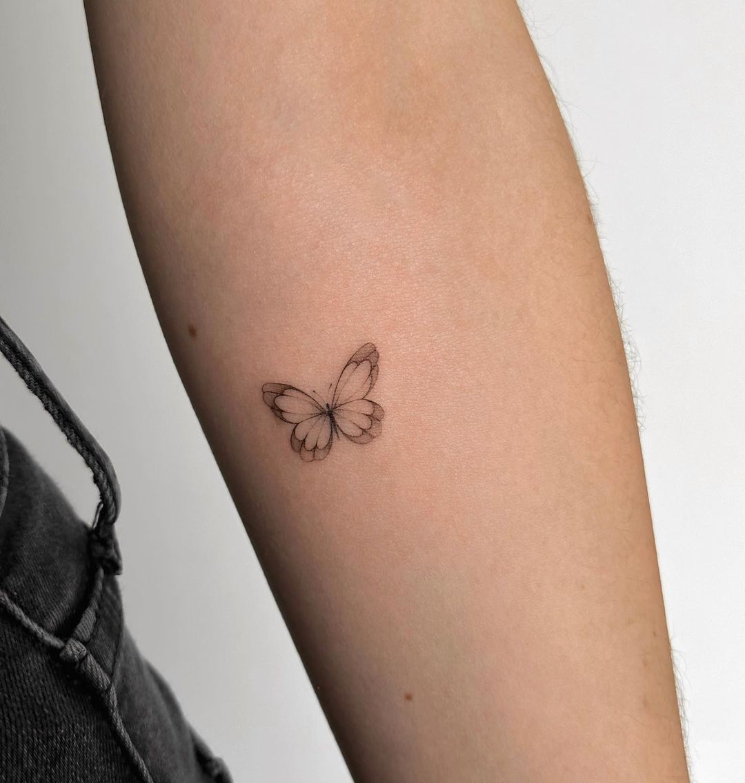 FIne line butterfly tattoo on the hip