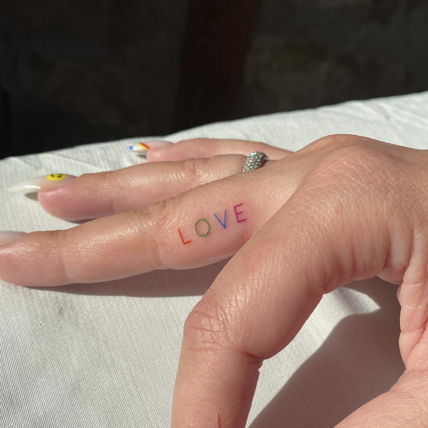 Colorful Love Word Tattoo on Middle Finger