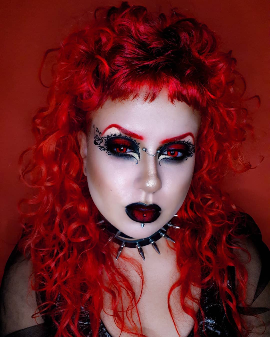 Maquiagem gótica com sombra vermelha e preta e sobrancelhas vermelhas