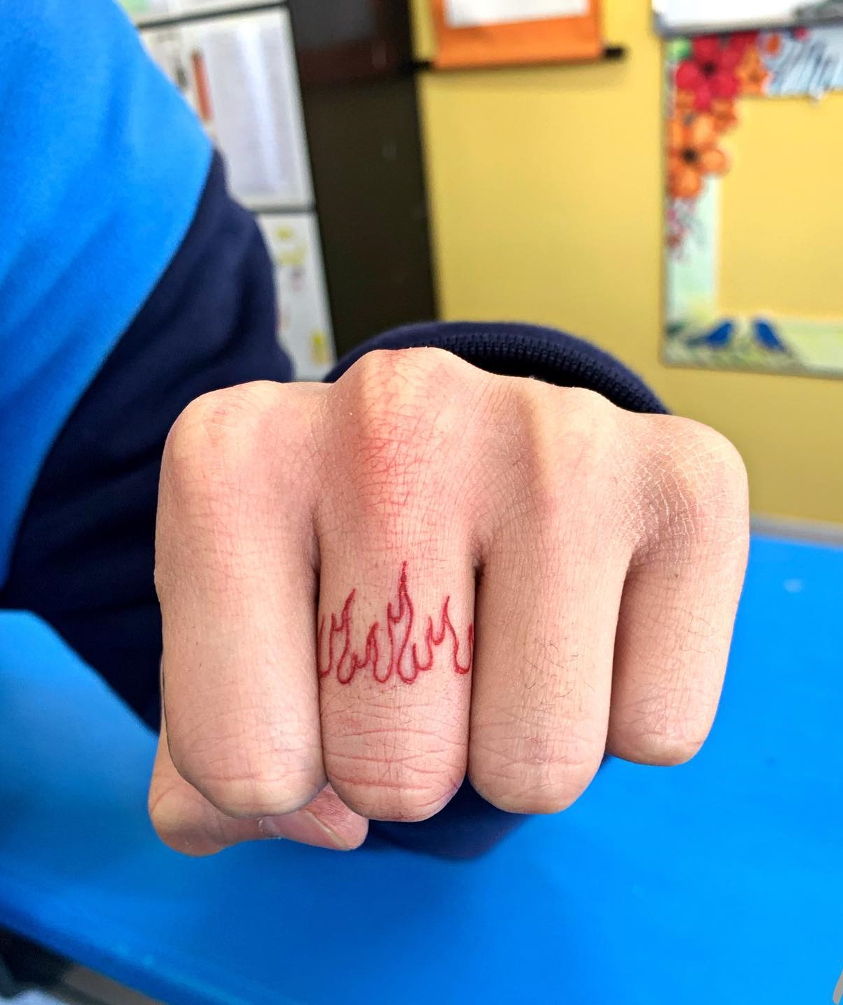 Red Flame Tattoo on Middle Finger