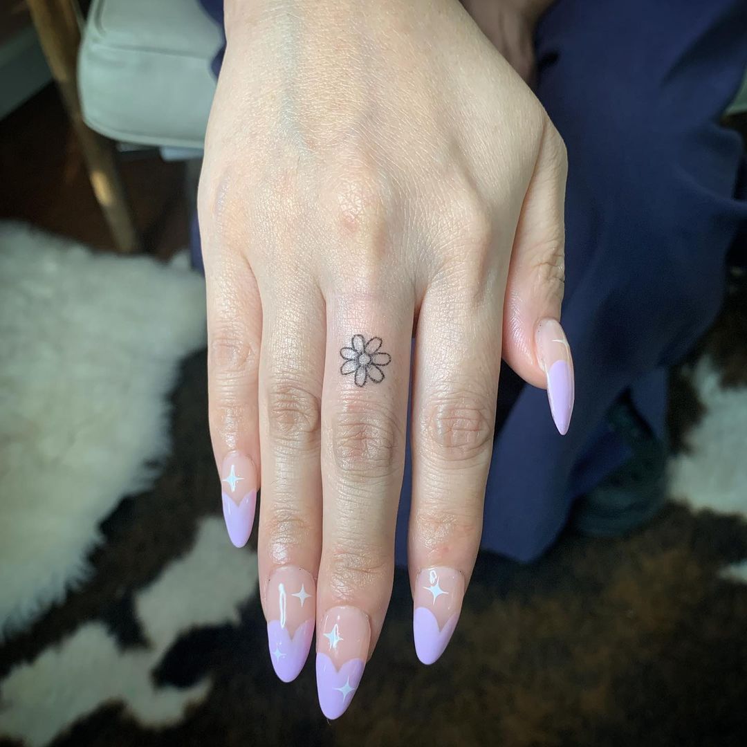 Minimalist daisy tattoo on the wrist