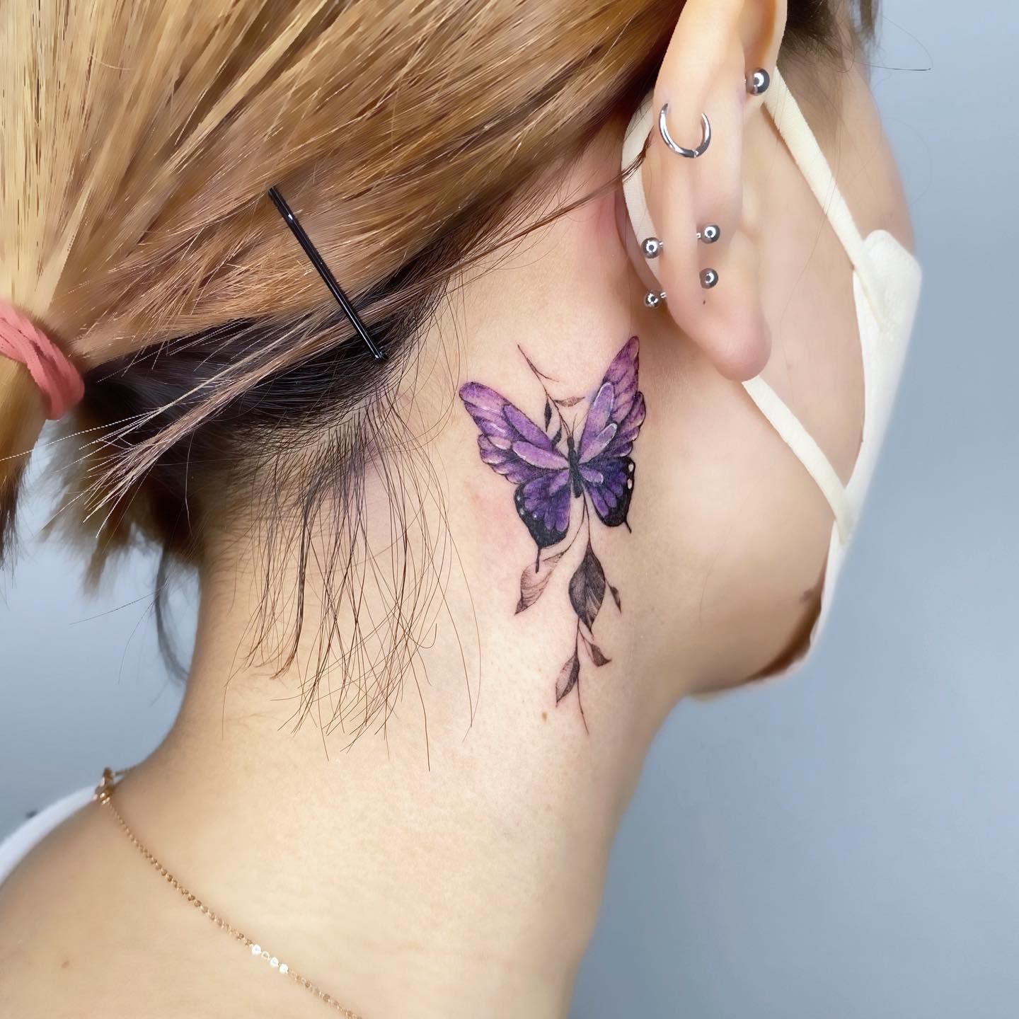 Minimalist butterfly tattoo behind the ear