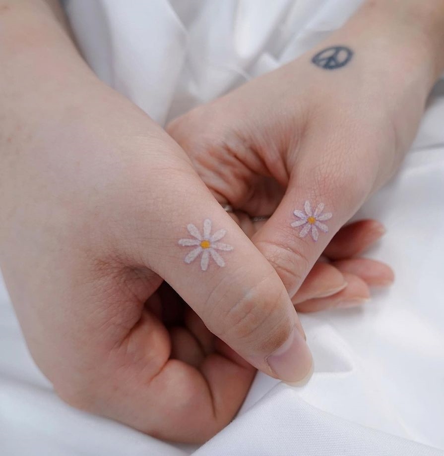 Tiny Daisy Matching Tattoos on Thumbs