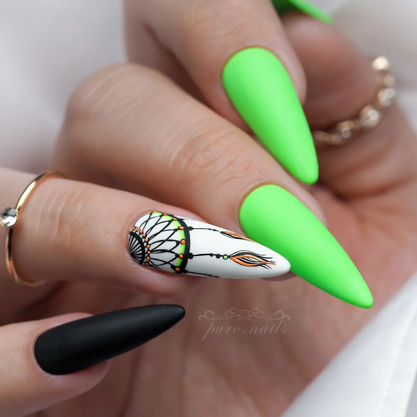 Uñas de neón largas y puntiagudas en verde y negro con diseño