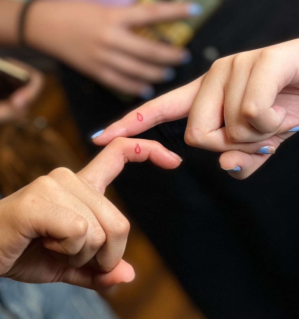 Tiny Red Droplet Tattoos on Index Fingers