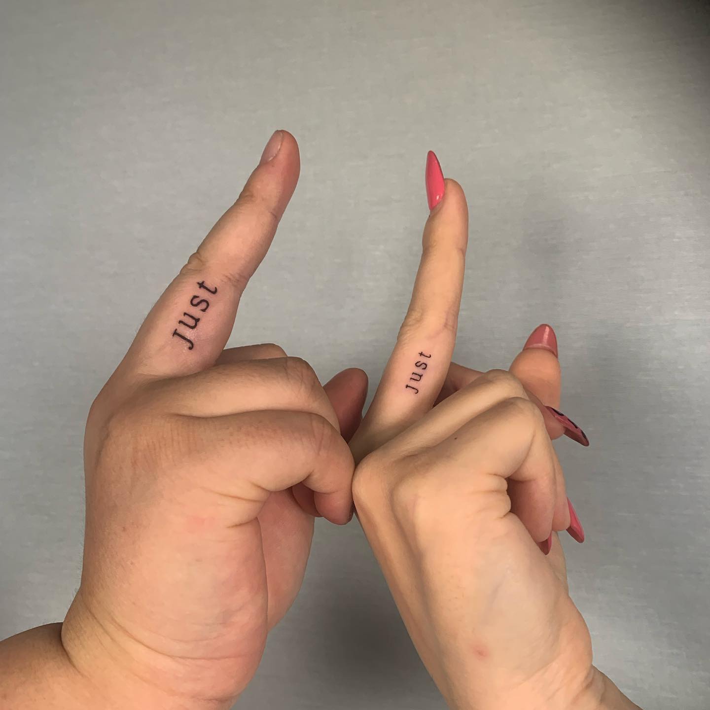 Matching “Just” Word Tattoo Inside Middle Fingers