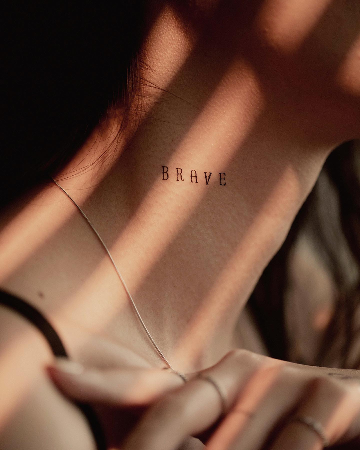 Mini 'Brave' Word Tattoo on Neck