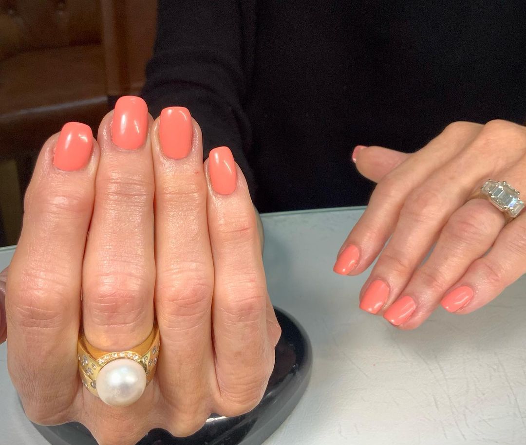 Peach nude nail design with a girly and vibrant shade
