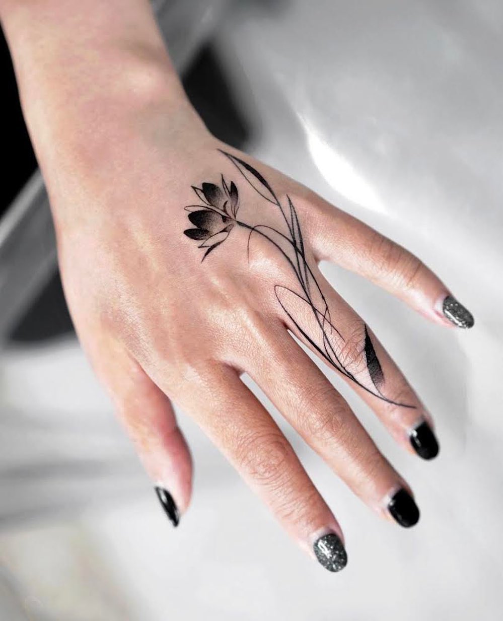 Black Lotus Tattoo on Ring Finger and Hand