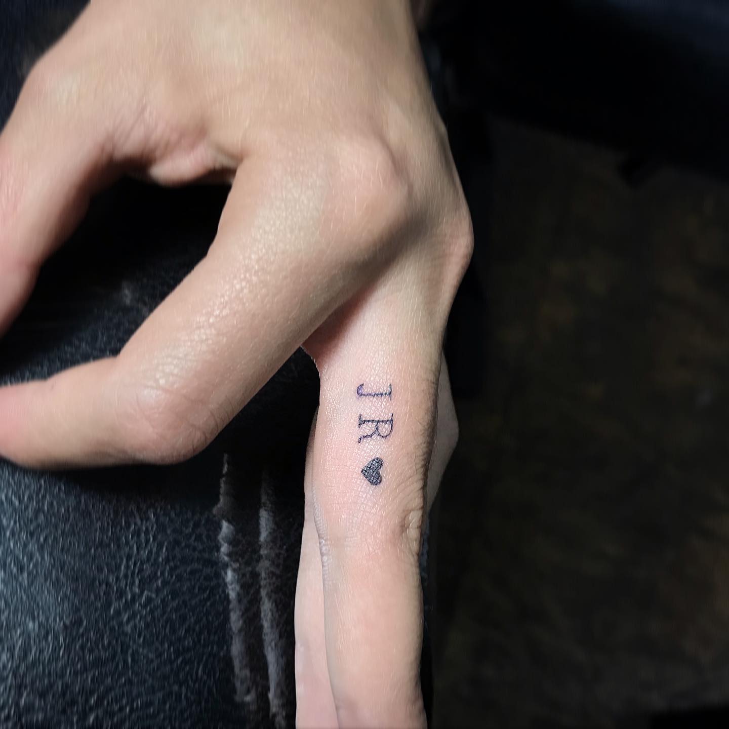 JR Letters Tattoo on Middle Finger
