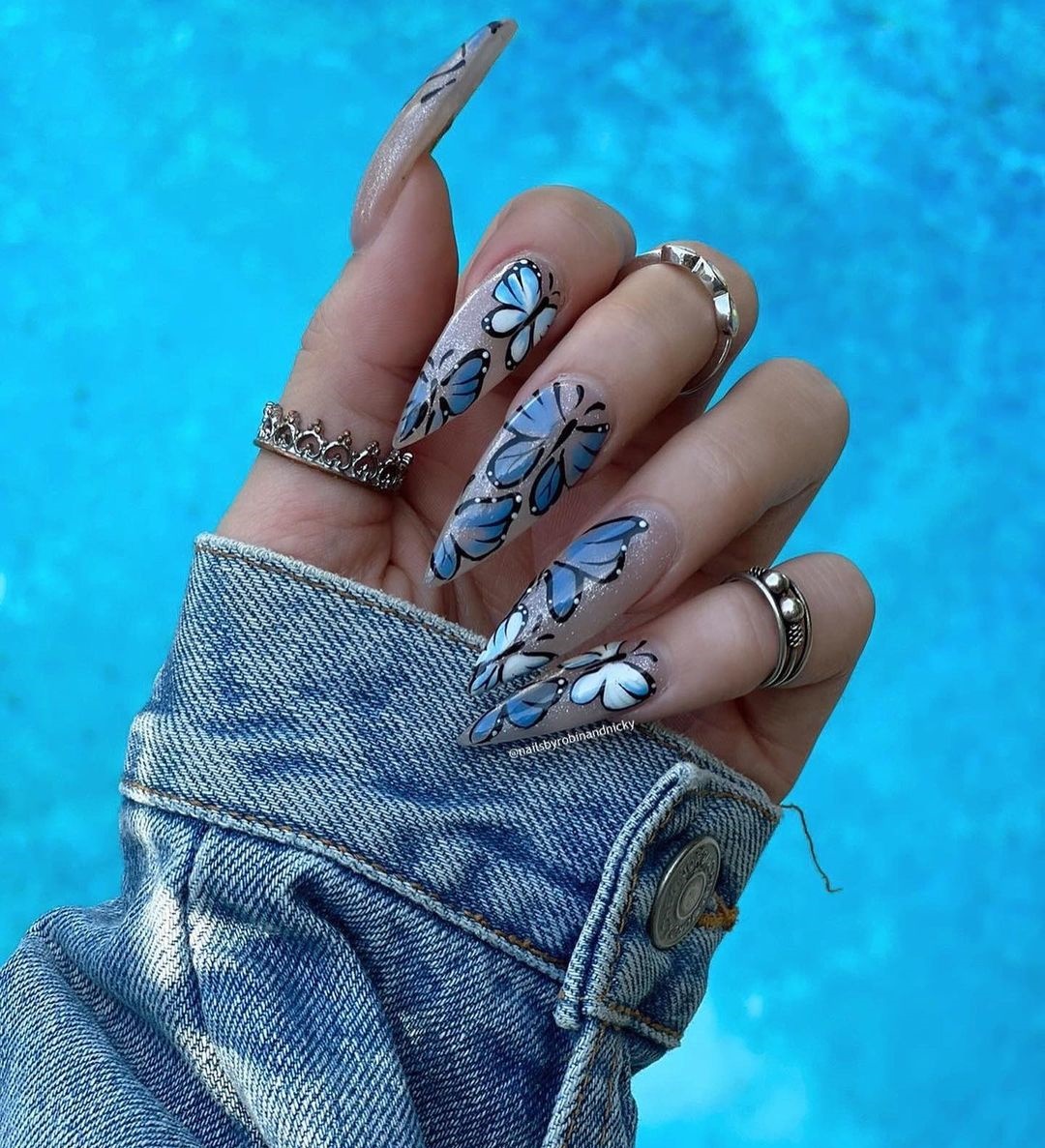 Long Clear Nails with Blue Butterfly Design