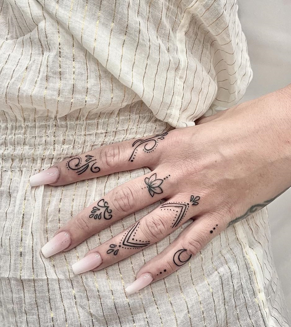 Tiny Black Lotus Tattoo on Middle Finger