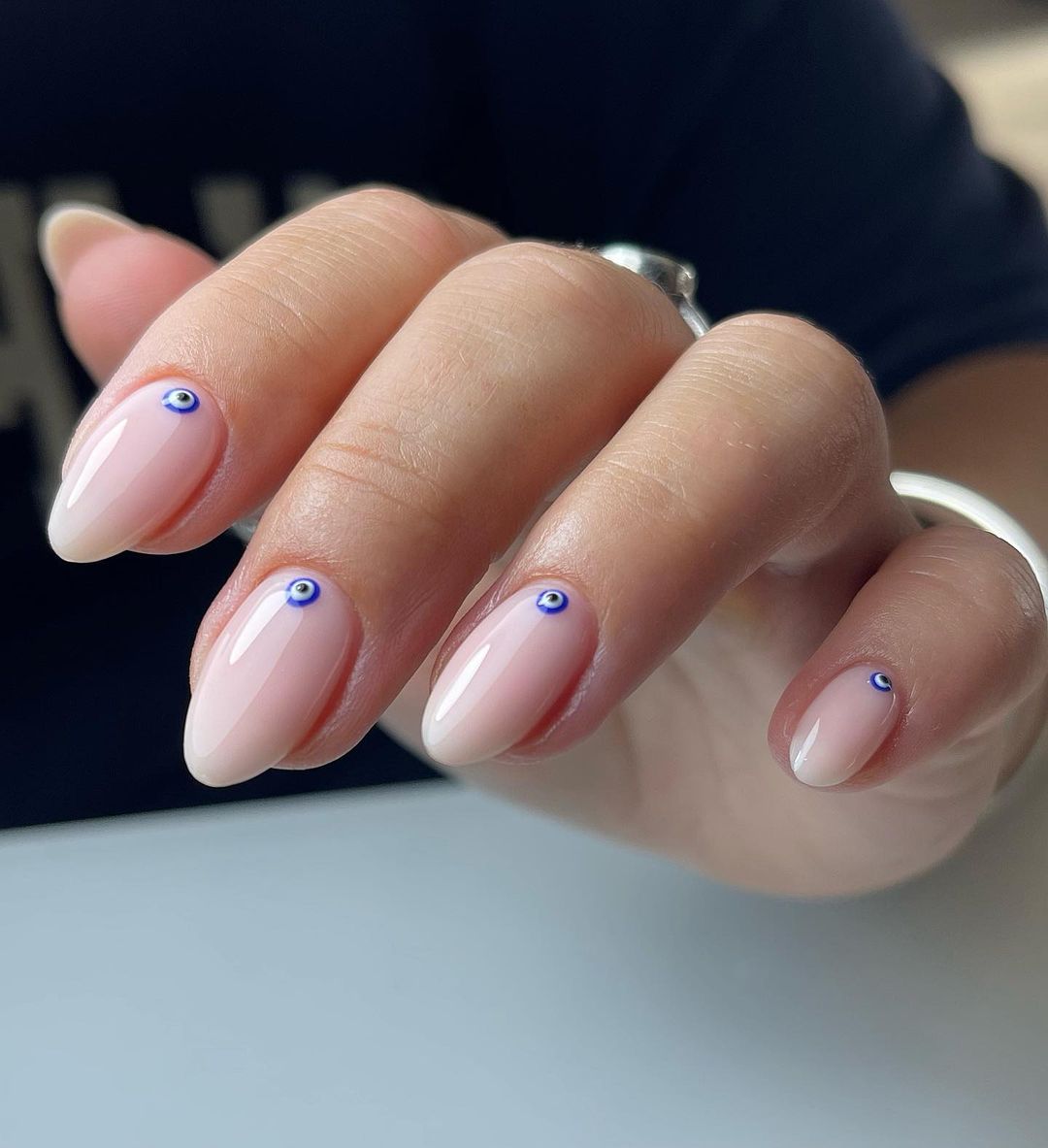 Short Almond Nude Nails with Blue Eye Design