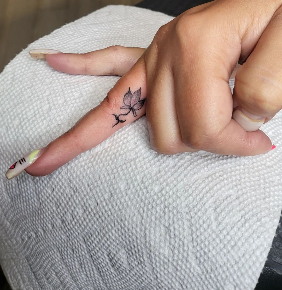 Small Black Lotus Tattoo Inside Ring Finger