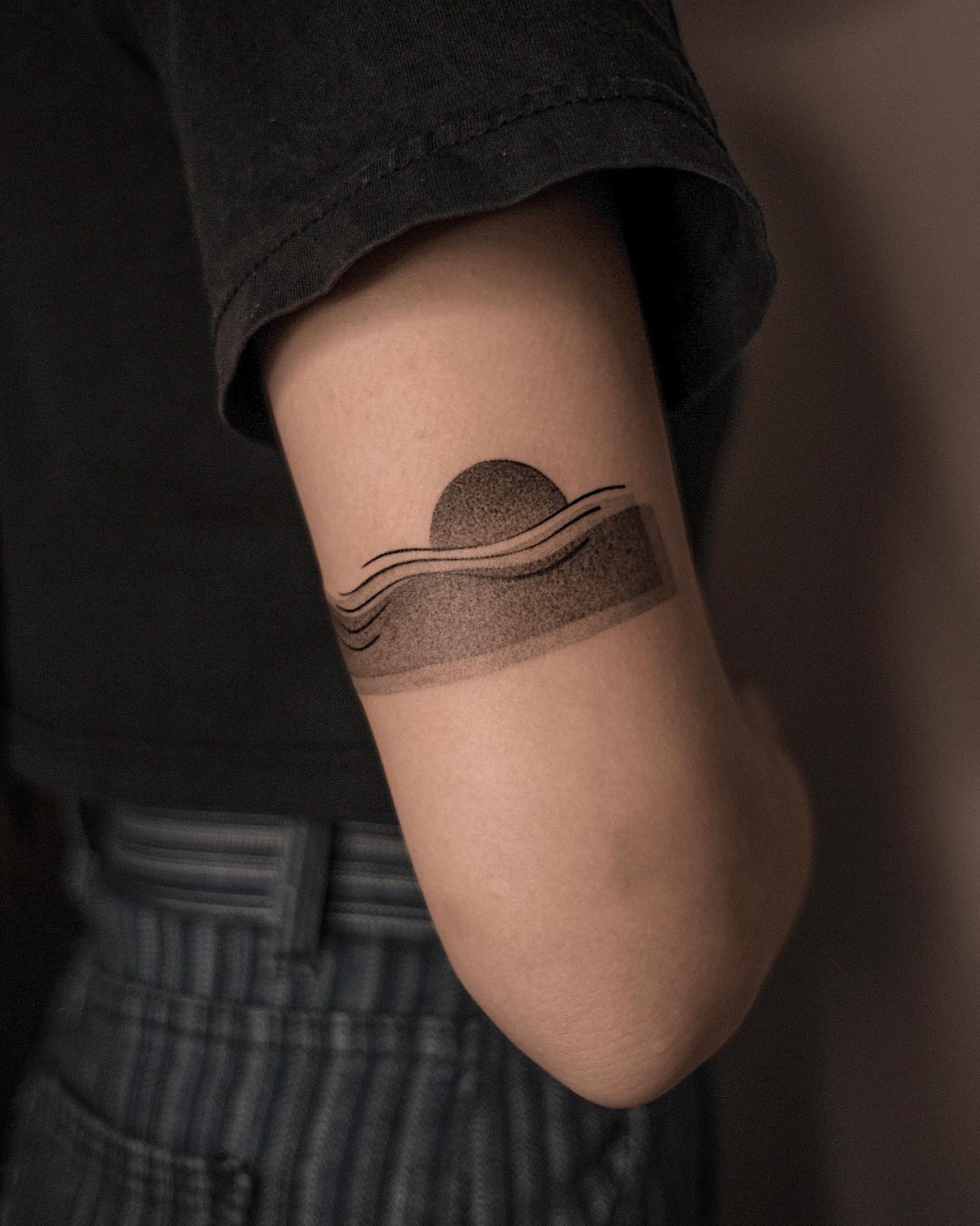 Wave and Sun Set Tattoo on the Back of the Arm