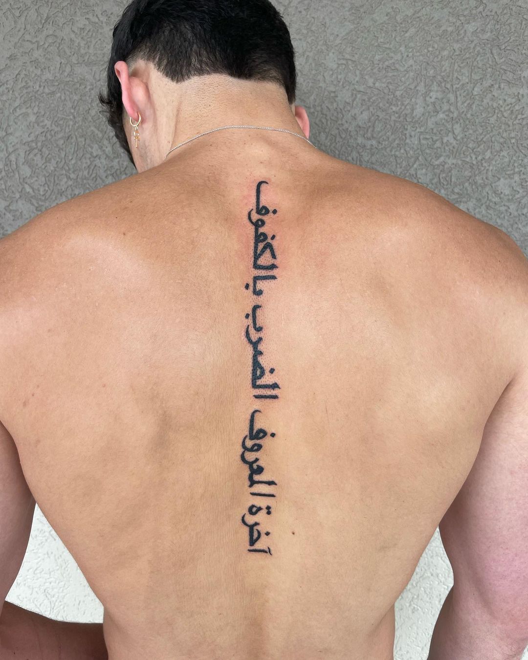 Arabic Quote Tattoo Along Spine for Men