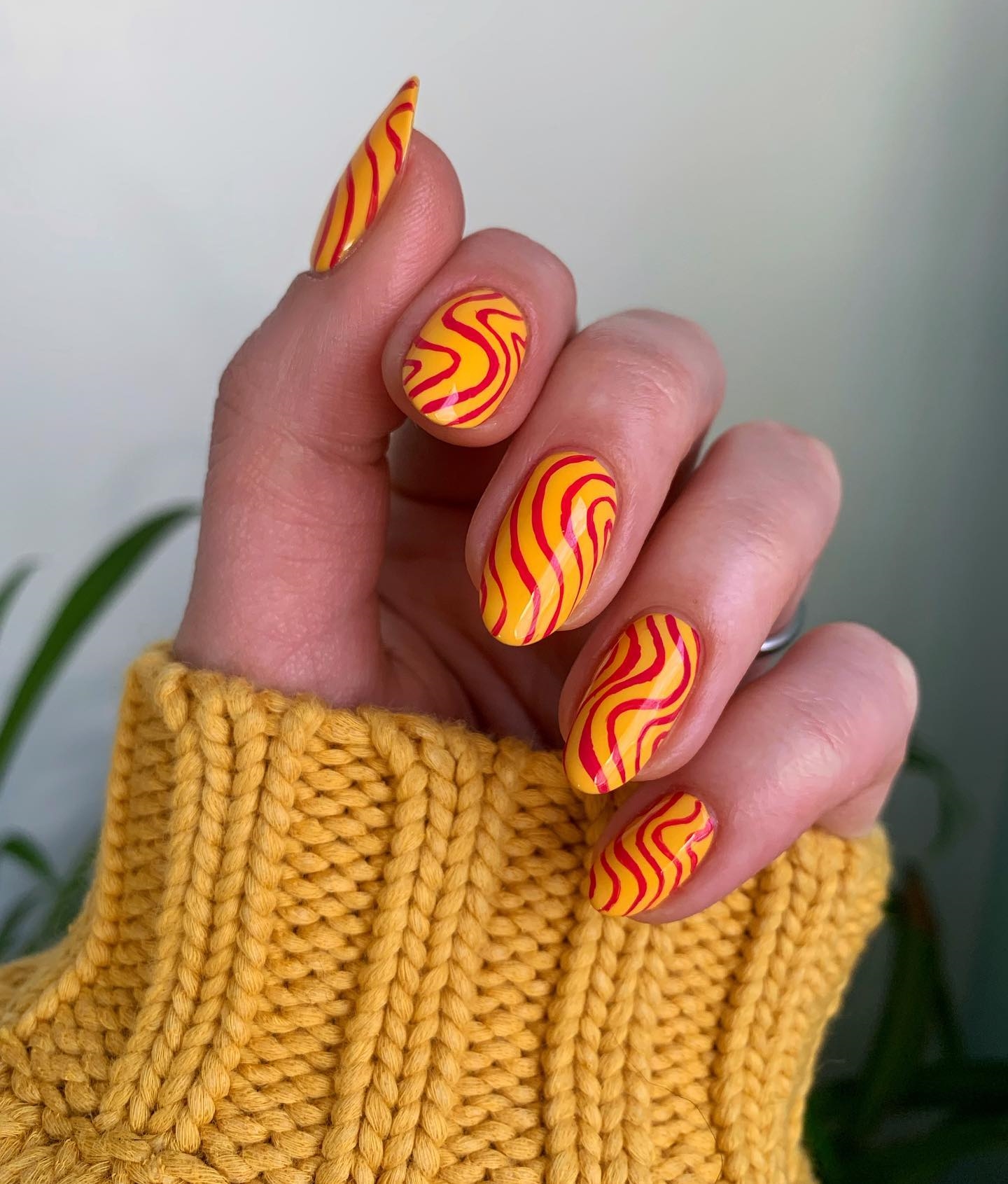 Short Round Yellow Nails with Red Swirls