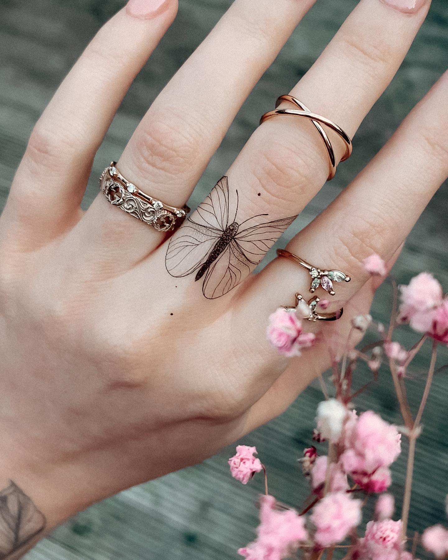 Tiny Butterfly Finger Tattoo